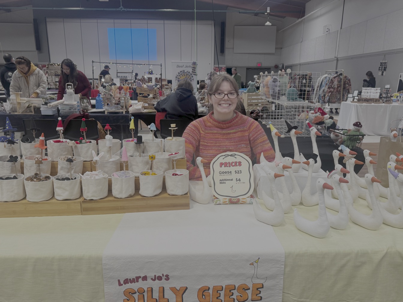 Laura Jo at her market table surrounded by geese